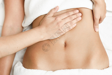 双手按摩女性腹部治疗师腹部高清图片