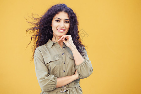 年轻的阿拉伯女人,时尚模特,城市背景下留着卷发年轻的阿拉伯女人,卷发户外令人愉快的高清图片素材