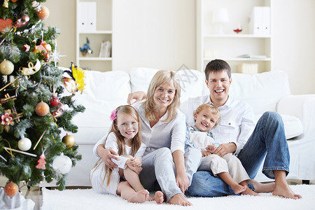 年轻的笑声家庭与云杉背景图片