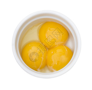 明亮的黄色鸡蛋白色背景上分离的白色碗中蛋黄背景图片