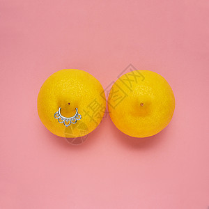 乳头内陷创意食品健康时尚照片柠檬形状的女性乳房与乳头穿孔粉红色背景背景