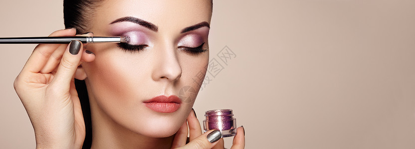 粘滞剂化妆师应用眼影漂亮的女人脸完美的妆容化妆细节美丽的女孩有完美的皮肤指甲指甲背景