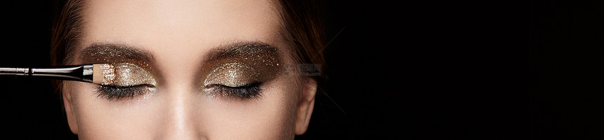 化妆师应用眼影漂亮的女人脸完美的妆容嘴唇化妆品眼影化妆细节眼线图片