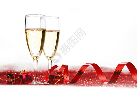 带香槟红色礼物的眼镜白色背景上闪闪发光闪光的香槟图片