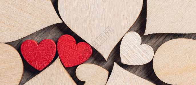 两颗木制的红心许多无色的木心中涂上两颗木制的红色心背景图片