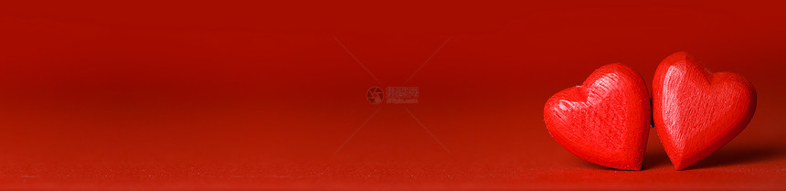 两颗手工制作的红色木心红色背景情人节卡片上红色背景上的两颗心图片
