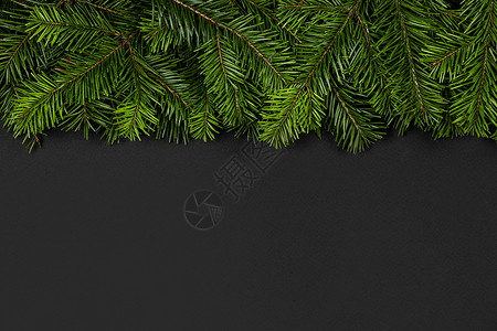 圣诞边界安排与新鲜冷杉树枝黑色纸背景,的文本冷杉树枝的圣诞边界图片