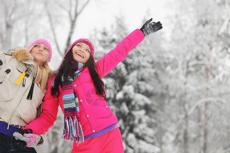 快乐的女孩,女性朋友雪覆盖的冬季公园玩得开心冬天公园的快乐女孩图片