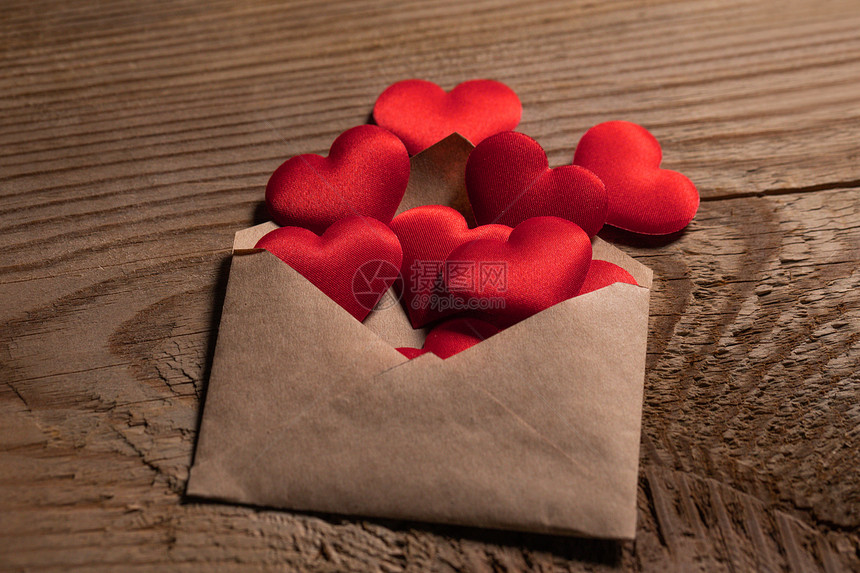 情人节情书,信封用红心堆铺木底情人节情书图片