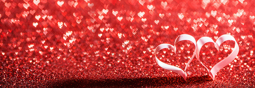 两颗红色丝带的心闪光的背景与的文本,情人节的闪闪发光的红丝带心图片