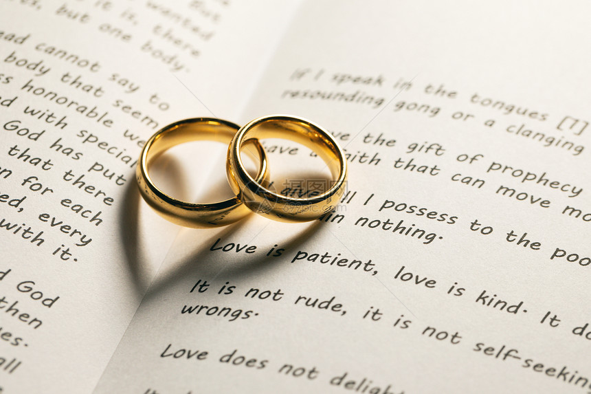 两个金色的结婚戒指神圣的圣经书上与心形阴影圣经书上的金色结婚戒指图片