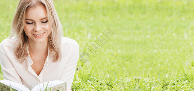 年轻漂亮的女人躺绿色的草地上看书,春天的考试,课文的女人躺草地上看书背景图片