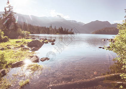 平静的景色山湖边,岩石平静的水中反射图片