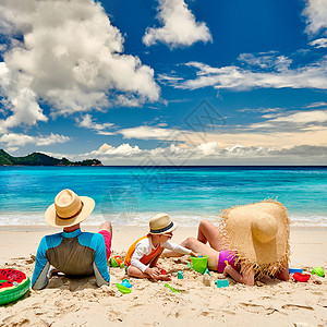海滩上的家人,有三岁男孩的年轻夫妇塞舌尔的暑假夏天高清图片素材