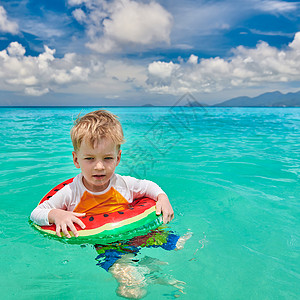 三岁的蹒跚学步的男孩塞舌尔海滩游泳与充气戒指马厄高清图片素材