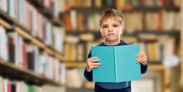 童年教育高兴的小男孩阅读书籍的图书馆背景高兴的小男孩图书馆看书图片