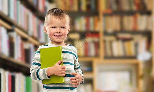 阅读,教育童年微笑的小男孩图书馆背景下书的肖像微笑男孩图书馆书的肖像图片
