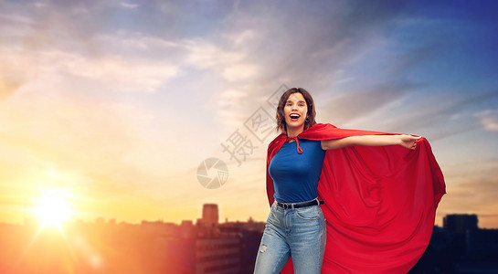 女孩穿着斗篷女人的力量人的快乐的女人红色超级英雄披风日落城市背景快乐的女人穿着红色超级英雄斗篷城市日落背景