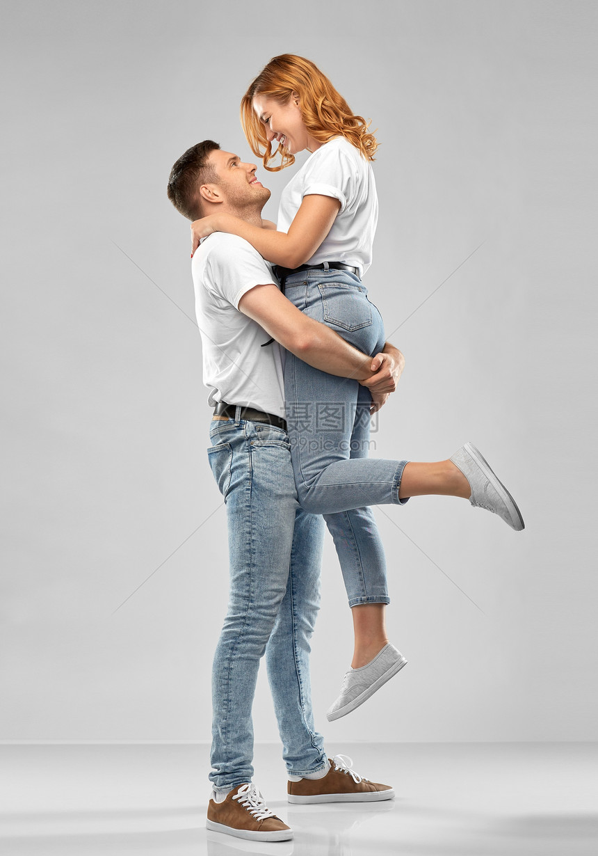 关系人的幸福的夫妇白色T恤灰色背景穿着白色T恤的幸福夫妇图片