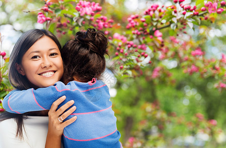 家庭,母亲人的幸福微笑的母亲女儿拥抱樱花背景快乐的母女拥抱花园图片
