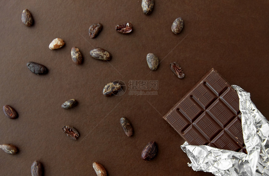 糖果,糖果食品黑色巧克力棒箔包装可可豆棕色背景黑巧克力棒箔纸可可豆图片