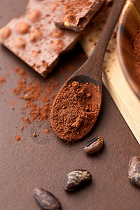 糖果,糖果烹饪可可粉木制勺子与巧克力豆类棕色背景巧克力木勺上的可可粉背景图片