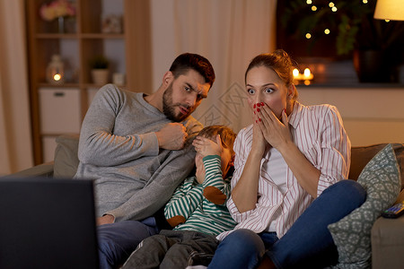 家庭休闲人的害怕父亲母亲小儿子晚上家看电视害怕的家人晚上家看电视图片