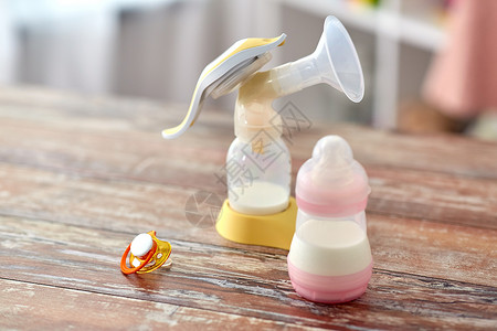 喂养奶瓶与婴儿牛奶配方,肥皂母乳泵木制桌子家里带有婴儿奶粉母乳泵的瓶子图片