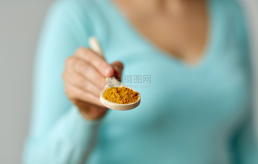 食物,烹饪健康的饮食接近女人与咖喱木勺上把咖喱放木勺上的女人关起来图片