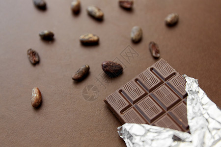 糖果,糖果食品黑色巧克力棒箔包装可可豆棕色背景黑巧克力棒箔纸可可豆图片