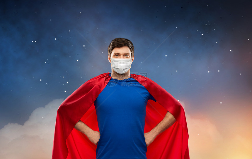 健康安全大流行快乐的年轻人穿着红色超级英雄斗篷,戴着面部防护医学面具,星空背景下抵御病疾病晚上戴着面罩的超级英图片