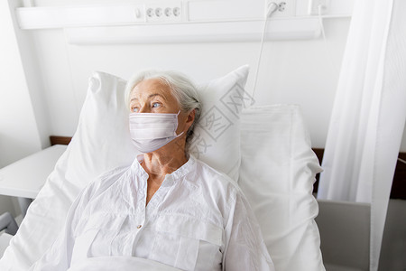医学,健康安全大流行老年妇女病人躺床上,戴着面部防护医疗面罩,以防止医院病房的病疾病老妇病人戴着面具躺医院的床呼吸系统高清图片素材