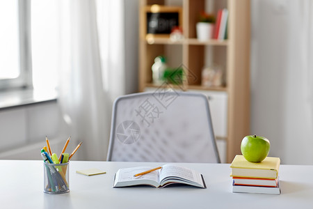 教育学书籍,苹果学校用品家里桌子上家里桌子上有书苹果学用品背景图片