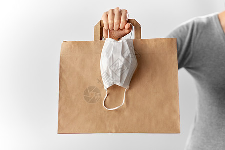 健康保护,安全购物大流行妇女与纸袋外卖食品面部防护医疗面具带购物袋面罩的女人背景图片