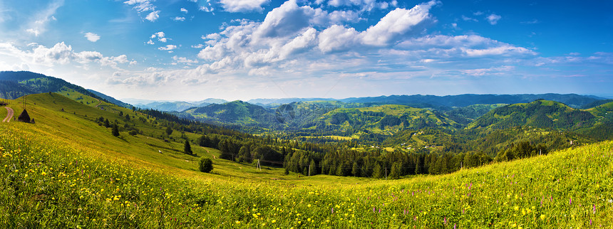 阳光明媚的天,山谷中山地草地的全景背景上的森林村庄欧洲旅行,喀尔巴阡山脉,乌克兰图片