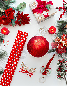 红色圣诞装饰包装纸白色桌子上,上面有冷杉树枝圣诞花上面的风景平躺背景图片