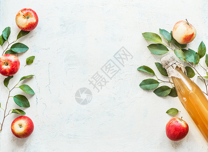 瓶子与自制苹果醋与苹果绿叶白色背景框架苹果季节健康发酵食品的背景图片