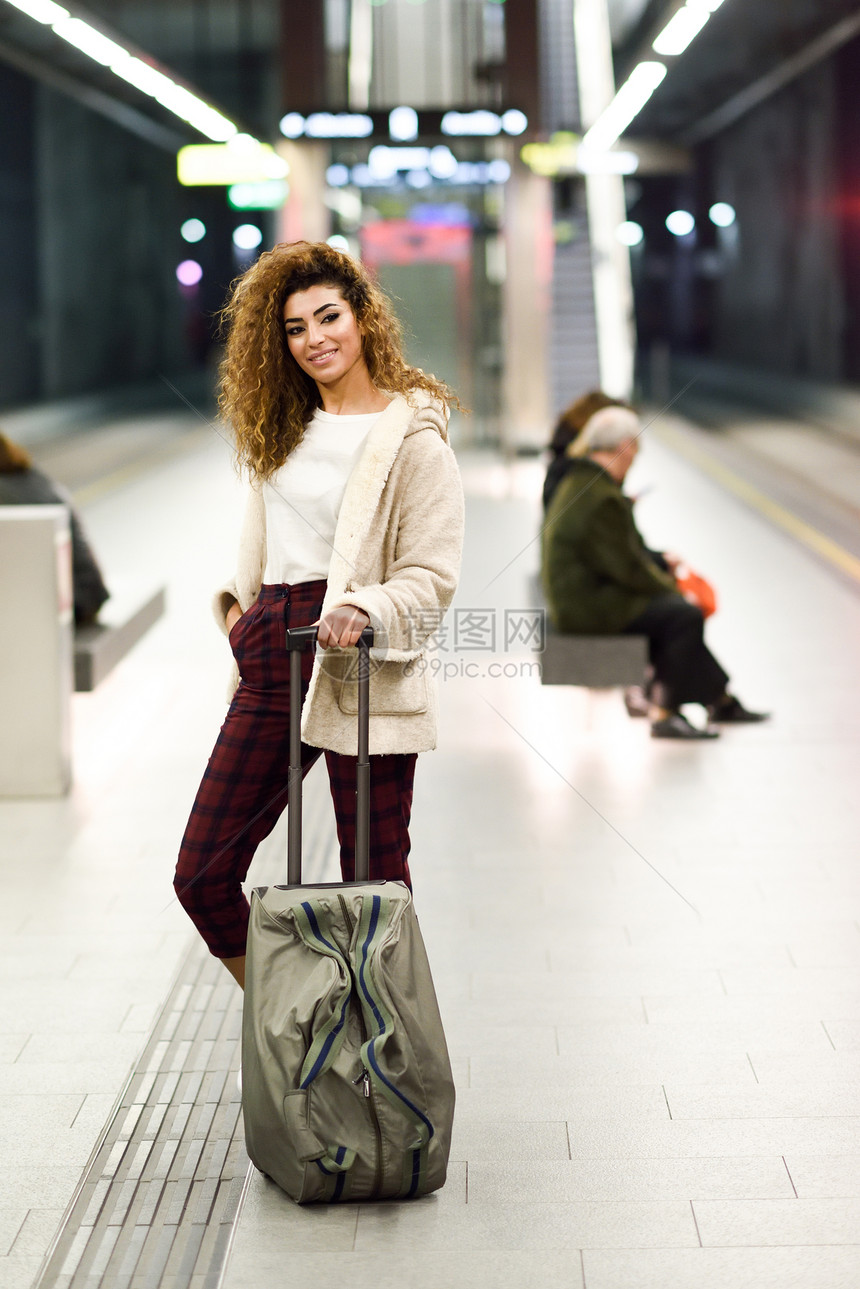 美丽的年轻阿拉伯女人地铁站等她的火车穿着休闲服的阿拉伯旅行者年轻的阿拉伯女人地铁站等她的火车图片
