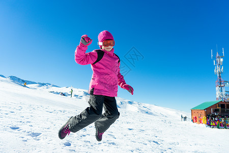 小女孩穿着雪服内华达山脉滑雪胜地的雪地上跳小女孩内华达山脉滑雪胜地的雪地上跳背景图片