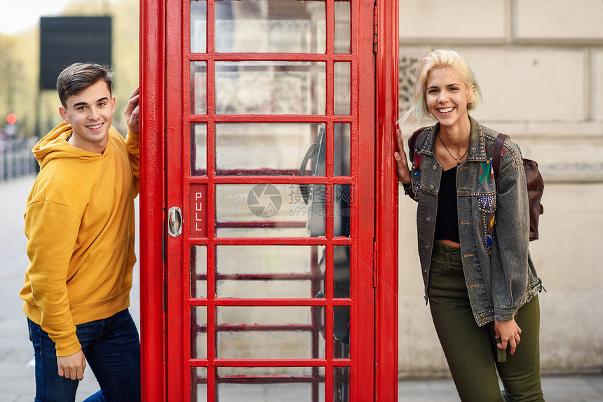 年轻快乐的朋友个经典的英国红色电话亭附近年轻的朋友个经典的英国红色电话亭附近图片