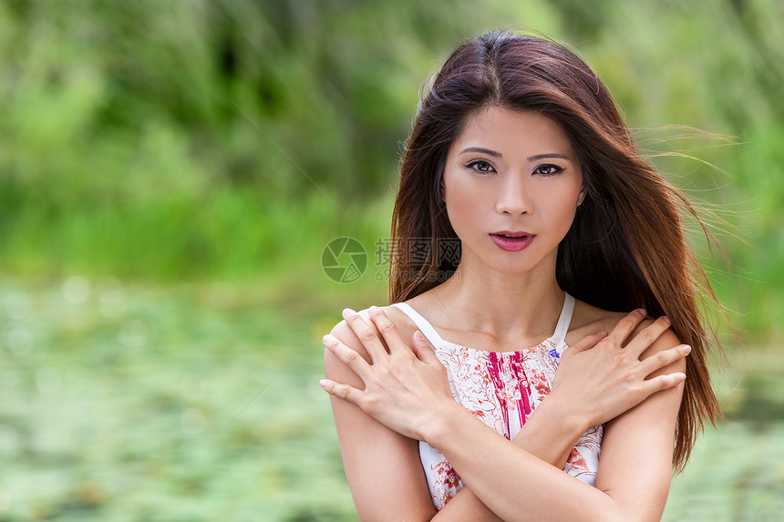户外肖像,美丽的中国亚洲轻妇女完美的手臂交叉她的胸部图片