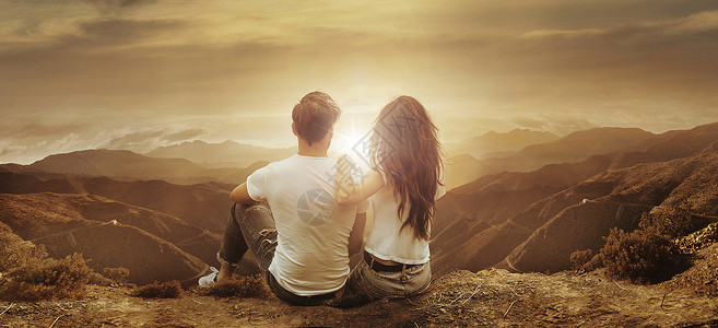 年轻放松的夫妇看着美丽的日落高清图片