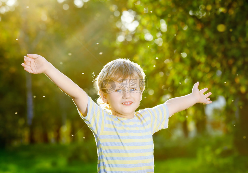 微笑的小男孩张开双臂个夏天的花园里图片