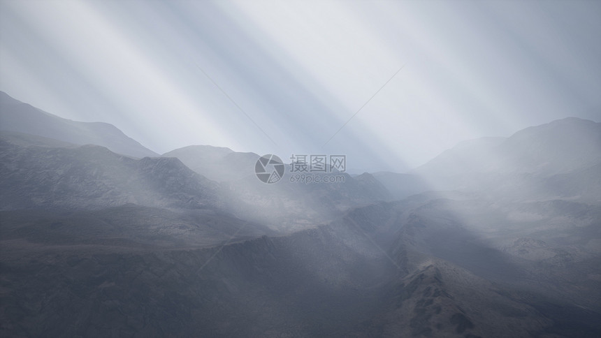 太阳的光线山脉的背景下,前景的熔岩岩石潮湿的海岸上阳光照射群山的背景上图片