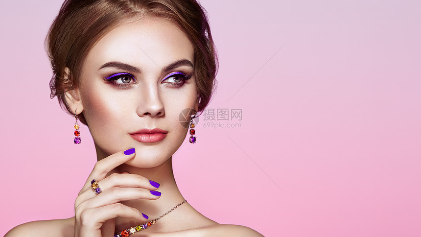 用珠宝描绘美丽的女人模特女孩用紫罗兰指甲修剪指甲优雅的发型紫色化妆箭头美容配饰图片