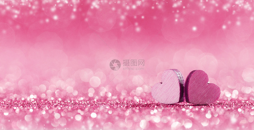 两颗手工制作的粉红色木心明亮的灯光背景下波基背景上的粉红色心脏图片