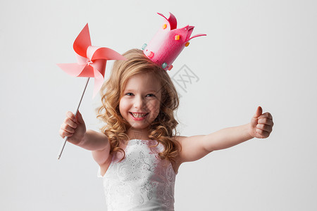 美丽的糖果公主女孩戴着皇冠,抱着风车,微笑着带风车的糖果公主女孩图片