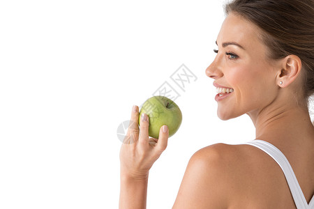 美丽的微笑,洁白有力的牙齿年轻女人的头肩膀带着雪白的牙齿微笑,着绿色的苹果,牙齿护理工作室隔离白色背景上着绿背景图片