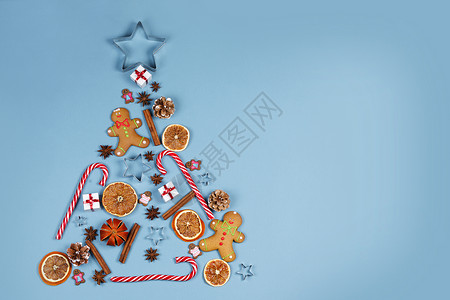 圣诞树由蓝色纸背景上的装饰制成圣诞节假期平躺圣诞节假期图片