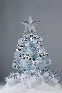 白色圣诞树,灰色背景上有银色的装饰品雪上的礼物圣诞树礼物图片